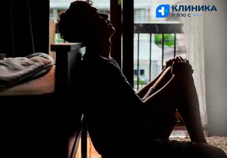 Грустный мужчина курит на балконе